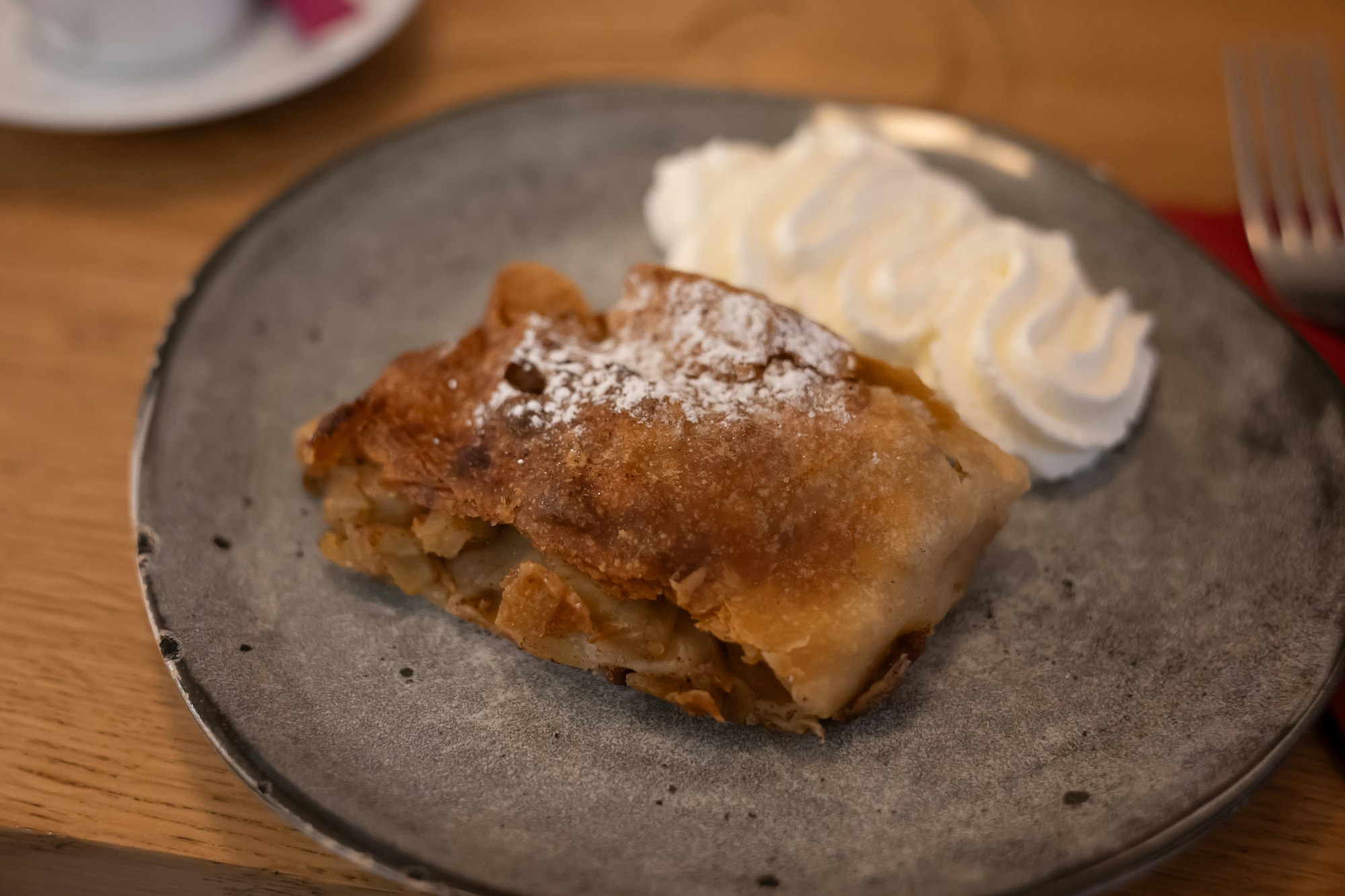A slice of Austrian apple strudel with whipped cream
