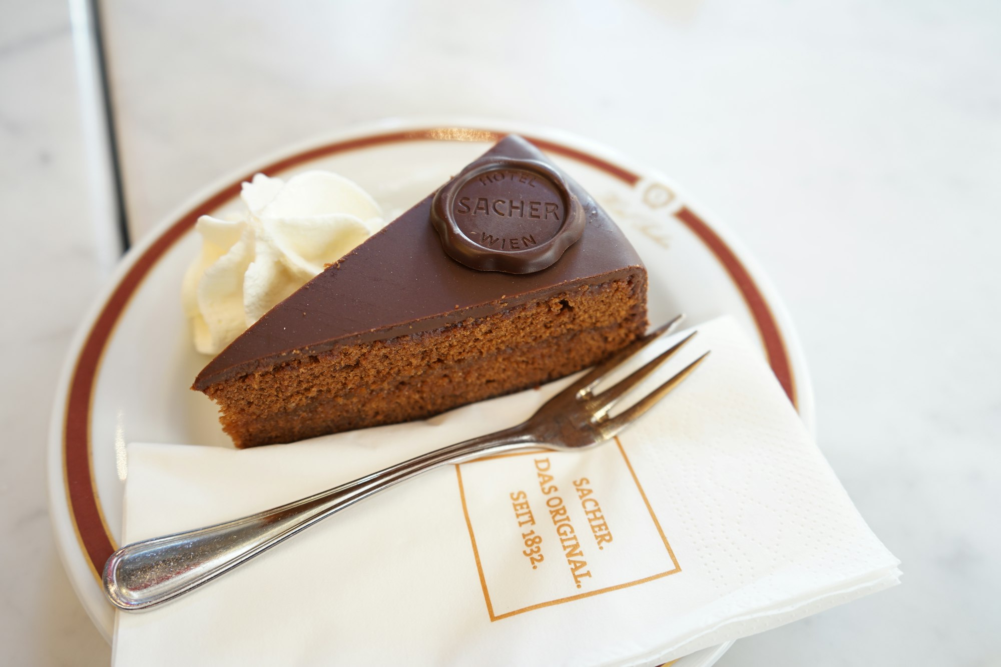 A slice of Austrian Sachertorte on a white plate